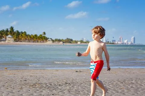 Active little kid boy having fun on Miami beach, Key Biscayne. Happy cute child Stock Photos