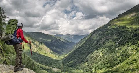 Active man with backpack and camping equipment at Imereteinka river valley ba 스톡 사진