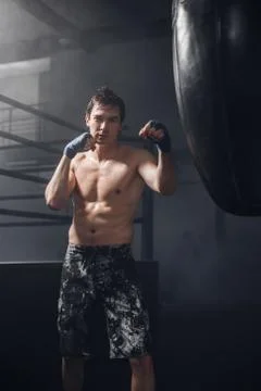 Active man with boxing wraps training punch for punching bag Stock Photos