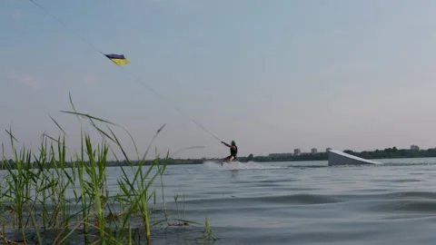 Active Man Cable Wakeboarding on Calm Lake Near Ramp with Ukrainian Flag Stock-Footage 341984153