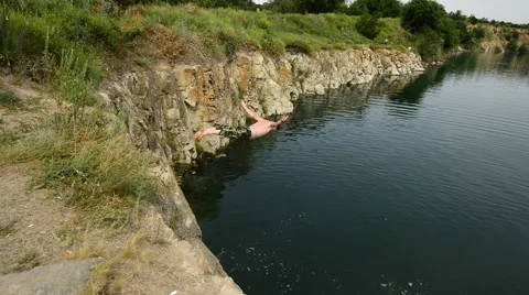 Active man dives off a cliff Video stock 64529653