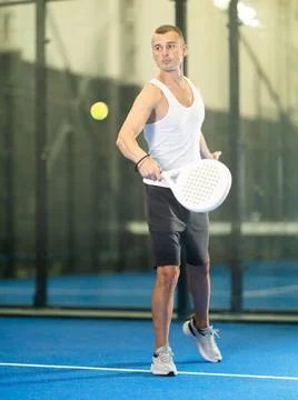 Active man with enthusiasm playing padel on tennis court Stock Photos