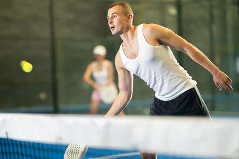 Active man with enthusiasm playing padel on tennis court Stock Photos