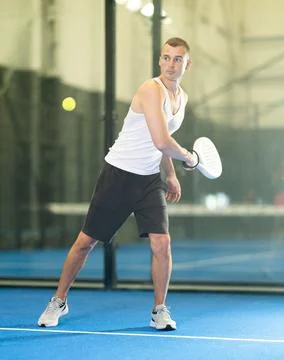 Active man with enthusiasm playing padel on tennis court Stock Photos