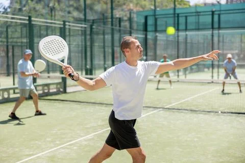 Active man with enthusiasm playing padel on tennis court Stock Photos