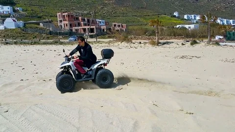 Active man having fun and getting extreme ride on quadcycle along sandy beach Stock Footage 84666790