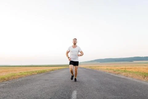 Active man jogging on road Stock Photos