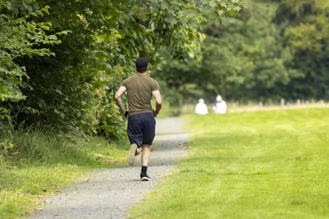 Active man jogging running along countryside footpath for exercise Stock Photos