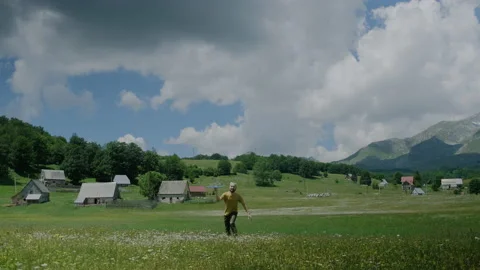 Active man millennial plays with a toy blue plane on  flower meadow Stock Footage 136662772