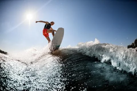 Active man rides on surf style wakeboard on the wave Stock-Fotos
