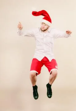 Active man in santa hat dancing and jumping. Stock Photos