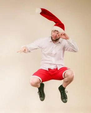 Active man in santa hat dancing and jumping. Stock Photos