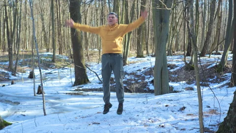 Active mature man performing jumping exercise outdoors in winter forest Stock Footage 335194328
