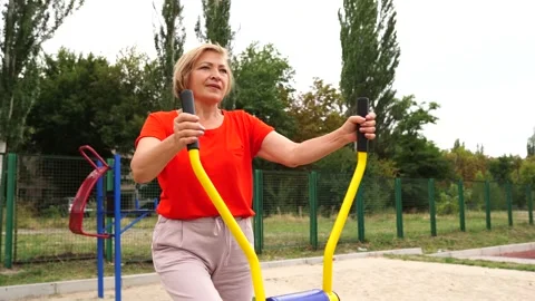 Active mature woman working out with various equipment outdoors on the stadium Stock Footage 156761253