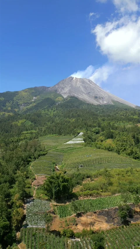 The active Merapi volcano and agricultural farmland on its slopes in Indonesia Stock Footage 280295338