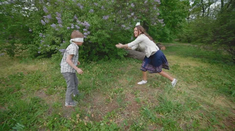 Active mom with her son on the lawn in the park catching each other Stock Footage 37677934