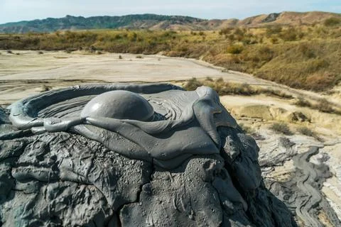 Active mud volcano eruption with a mud bubble captured in Romania Stock Photos