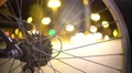 Active night city timelapse seen through bicycle wheel, hectic urban lifestyle 4k or 4k+ Resolution