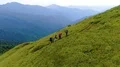 The active people with backpacks walking up on the beautiful mountain 4k or 4k+ Resolution