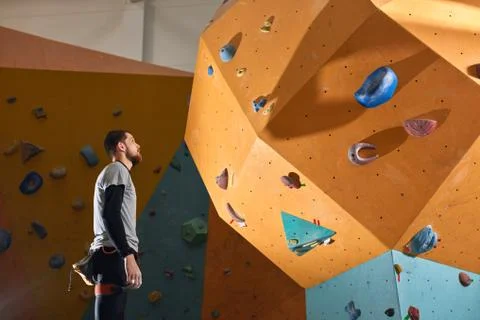 Active physically challenged boulderer stands near difficult climbing wall Stock Photos