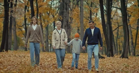 Active rest in nature in autumn, happy family walking holding hands in park, 4K Stock Footage 264503002