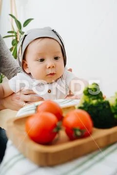 Active restless infant child is presented food Stock Photos