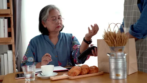Active Senior Asian Woman Using a Mobile Device for Contactless Payment 库存影片 237081246