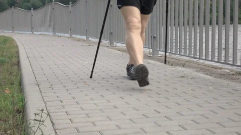 Active senior Caucasian man training Nordic walking with trekking poles Видео 121028843
