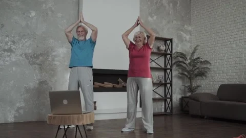 Active senior couple doing stretching exercise and watching online workout Stock Footage 142018410
