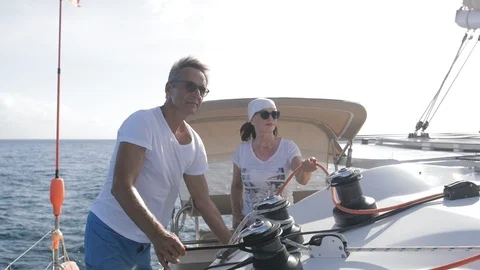 An active senior couple sailing 55 Stockbeeldmateriaal 99338412