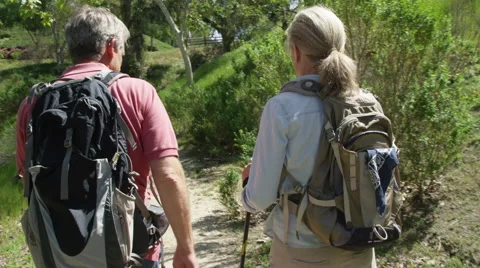 Active senior couple trekking on trail Stock Footage