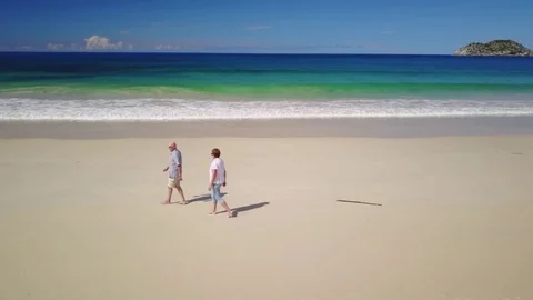 Active senior couple walking on beach Stock Footage 74650951