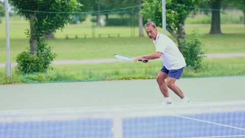 Active Senior Japanese Man Playing Tennis on Outdoor Court Stock-Footage 344010773