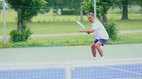 Active Senior Japanese Man Playing Tennis on Outdoor Court Stock-Footage 344013397