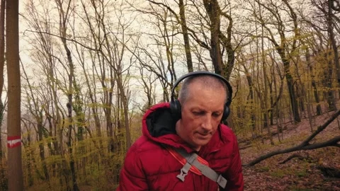 Active senior man hiking in spring forest wearing headphones, mature healthy Stock-Footage 333186299