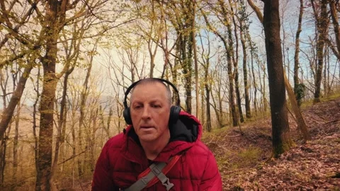 Active senior man hiking in spring forest wearing headphones, mature healthy Stock-Footage 333186346