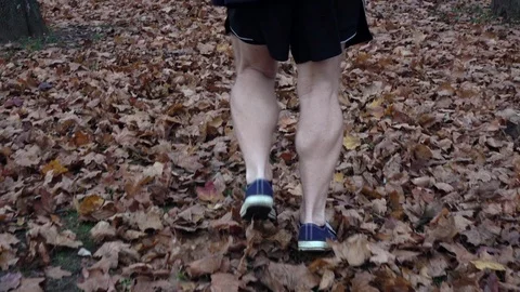 Active senior man slowly running for training legs on fallen dry leaves cover 動画素材 121030628