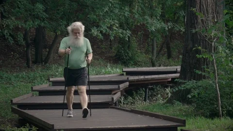 Active senior man training Nordic walking with trekking poles on wooden flooring Stock Footage 116055970