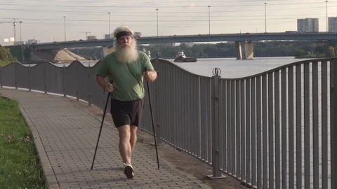 Active senior man training Nordic walking with trekking poles at urban area 库存影片 116056110