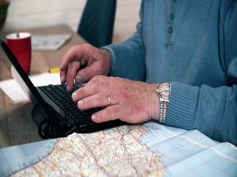 Active senior planning holiday vacation with laptop and map Video stock 74431906