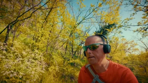 Active senior using tech in nature, man with headphones and sunglasses in Stock-Footage 334090705