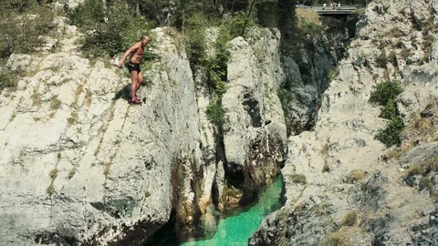 Active Senior On Vacation Jumping In Crystal Clear Water From A Lower Clif Stock Footage 94031992