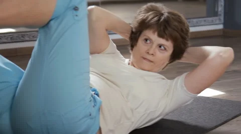 Active senior woman doing sit-ups crunches exercise workout Video stock 62652989
