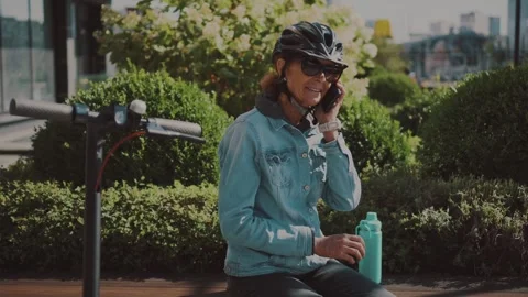 Active senior woman using an electric scooter in a city park. Modern micro Video stock 331318546