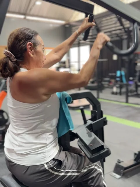 Active Senior Woman Working Back Muscles on Iso Lateral High Row Machine Видео 343545194
