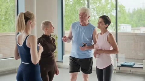 Active Seniors and Middle Aged Woman Talking to Female Trainer Stock Footage 339854643
