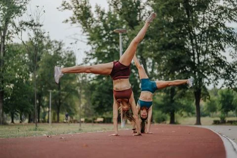 Active Sisters Show Impressive Flexibility and Strength in Outdoor Sports Stock Photos