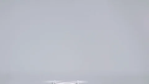 Active small white unmanned quadrocopter drone with action camera flying rising Stock Footage 126436493