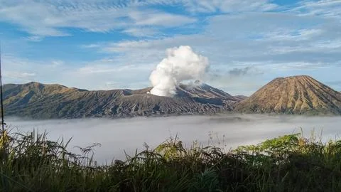 Active somma volcano Mount Bromo in East Java, Indonesia with steam rising from Stock Photos