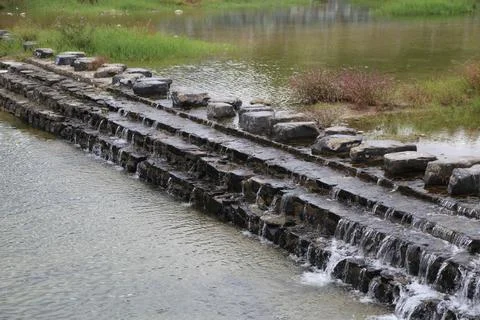 An active stone and metal structure that creates water flow along the edge .. Stock Photos